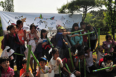 People gathered in front of the banner with their bird drawings